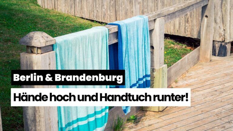 Blue towels hung over a wooden railing beside grass, with bold German headlines reading 'Berlin & Brandenburg' and 'Hände hoch und Handtuch runter!'