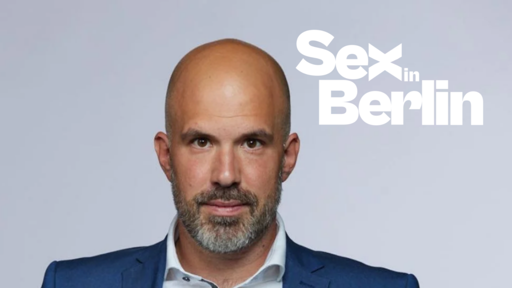 WEBSITE COVER - Sex in Berlin Man in a blue suit with a serious expression, against a gray background, with bold white text 'Sex in Berlin' on the right.